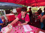 Kristen Ah Yek of Kristen's Sweet Delights waits on customers Saturday at the Vancouver Farmers Market.