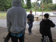 Vancouver police Cpl. Duane Boynton approaches two young men at Water Works Park last week. One of the boys, who identified himself only as Kyle, said that a group at the park whistles when they're about to attack someone.