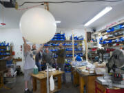 James Sutherland, from left, Kevin Cyrus, Rich Sutherland and Joe Barbera check out a helium-filled balloon that will be part of Sunday's unmanned test flight.