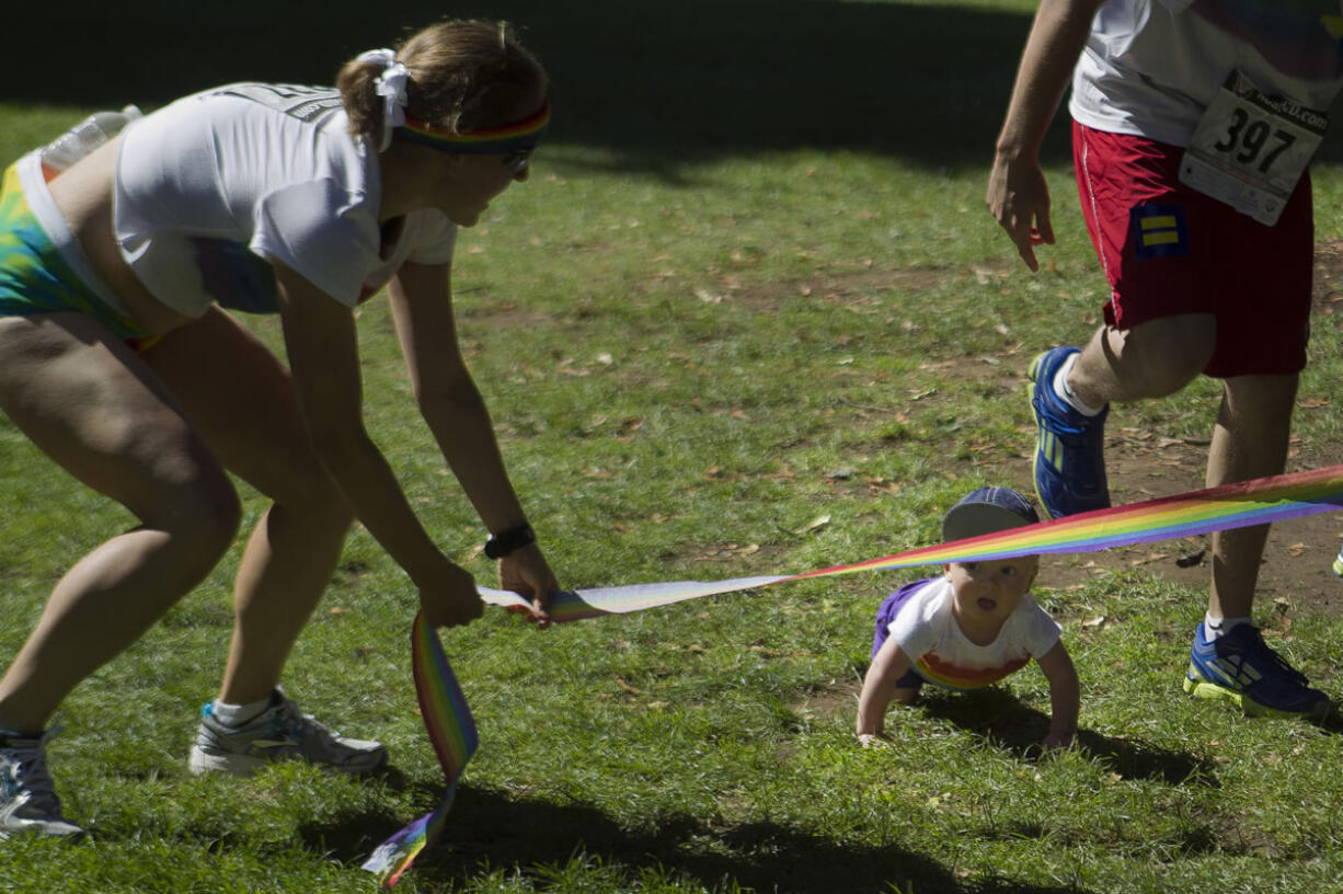 Amy Campbell holds the finish line low for 9-month-old Nolan O'Neill, the youngest &quot;competitor&quot; in the Lyle's Myles Run/Walk Saturday at Esther Short Park.