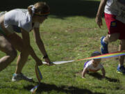 Amy Campbell holds the finish line low for 9-month-old Nolan O'Neill, the youngest &quot;competitor&quot; in the Lyle's Myles Run/Walk Saturday at Esther Short Park.