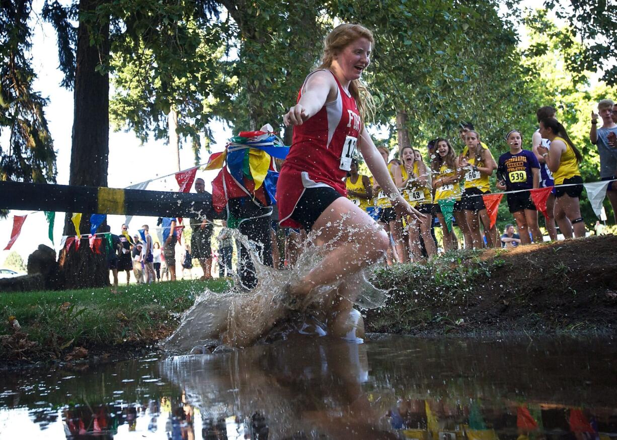 Fort Vancouver junior Carlie Latimer crosses the water hazard during the Run-A-Ree at Hudson's Bay on Friday.