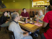 A small group, from left, Jenny Kidd, Kerry Giovanni, Sheryl Ingoe, Beverly Smith and Anjela Ford, all of Vancouver, communicate using American Sign Language during a monthly Deaf Coffee Night Monday at New Seasons Market in Fisher's Landing.