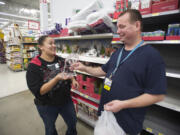 Walmart employee Bracken Harden, right, shows his award to co-worker Monique Mendez.