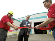 Pete Perez, facility manager at Sapa, from left, Mats Johansson, plant manager, and Greg Bartley, a die shop manager, cut the ribbon Friday to celebrate the opening of the company's new facility at the Port of Vancouver.