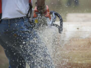 Sawdust flies as Charlie Davis, of Amboy, takes a run at the Chain Race during the annual Amboy Territorial Days celebrating Saturday local logging and pioneering history in Amboy.