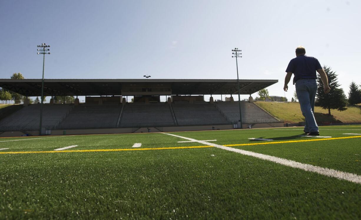 Patrick O'Day, construction project manager for Evergreen Public Schools, shows off the new turf that is being installed at McKenzie Stadium.