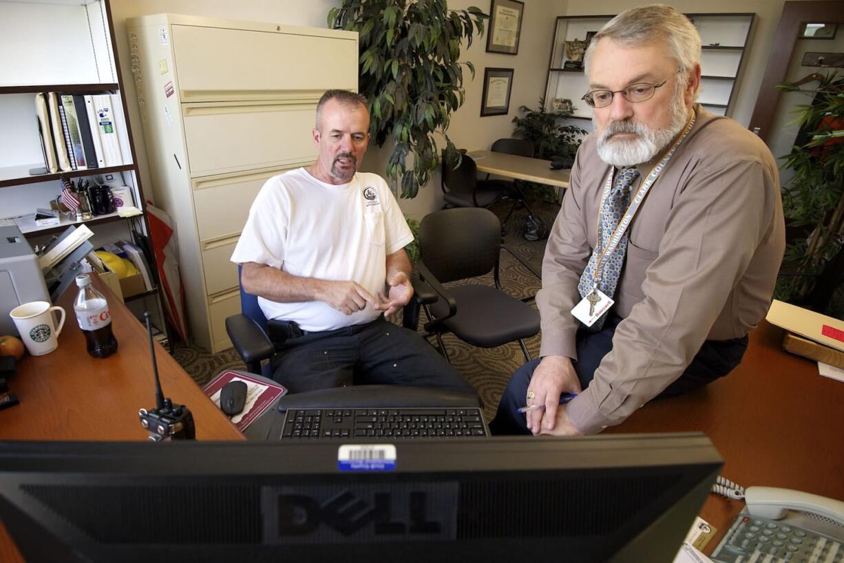 Clark County Risk Manager Mark Wilsdon, right, with Bob Moag, a facility maintenance specialist, track county vehicles via GPS Insight from Wilsdon's office at the Clark County Public Service Center in Vancouver.