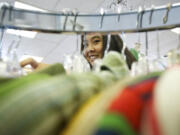 Skills Center student Julianne Cubacub, 17, sorts clothing at Deja Vu Consignment  on Tuesday.