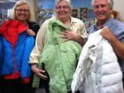 Washougal: Kathy Huff, left, Stephanie Welch and Gary Welch display some of the new and nearly new coats the congregation of The Calling Church donated for students in need at Hathaway Elementary School.