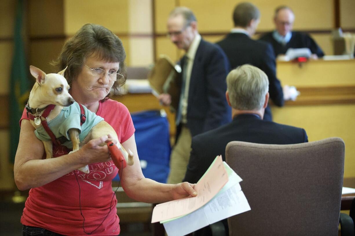 Hazel Trent, 52, of Vancouver leaves Clark County Superior Court Judge John Nichols' courtroom Tuesday with her service dog, Max. Trent appeared in court on accusations she stole her son's debit card in 2011 and withdrew more than $1,300 from his bank account.