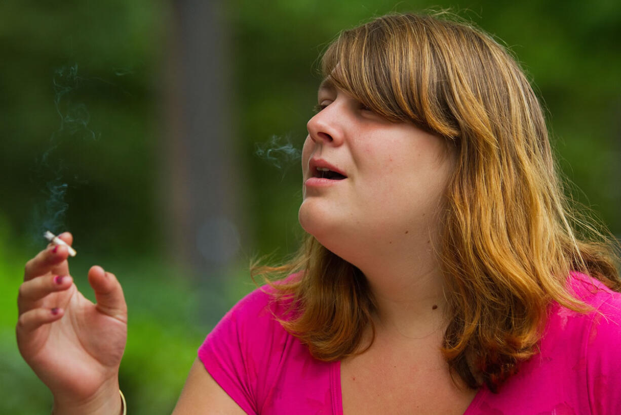 Jasmine Pursley exhales a puff of smoke after taking a drag on a cigarette on the sidewalk adjacent to Esther Short Park, across the street from City Hall, on Wednesday.