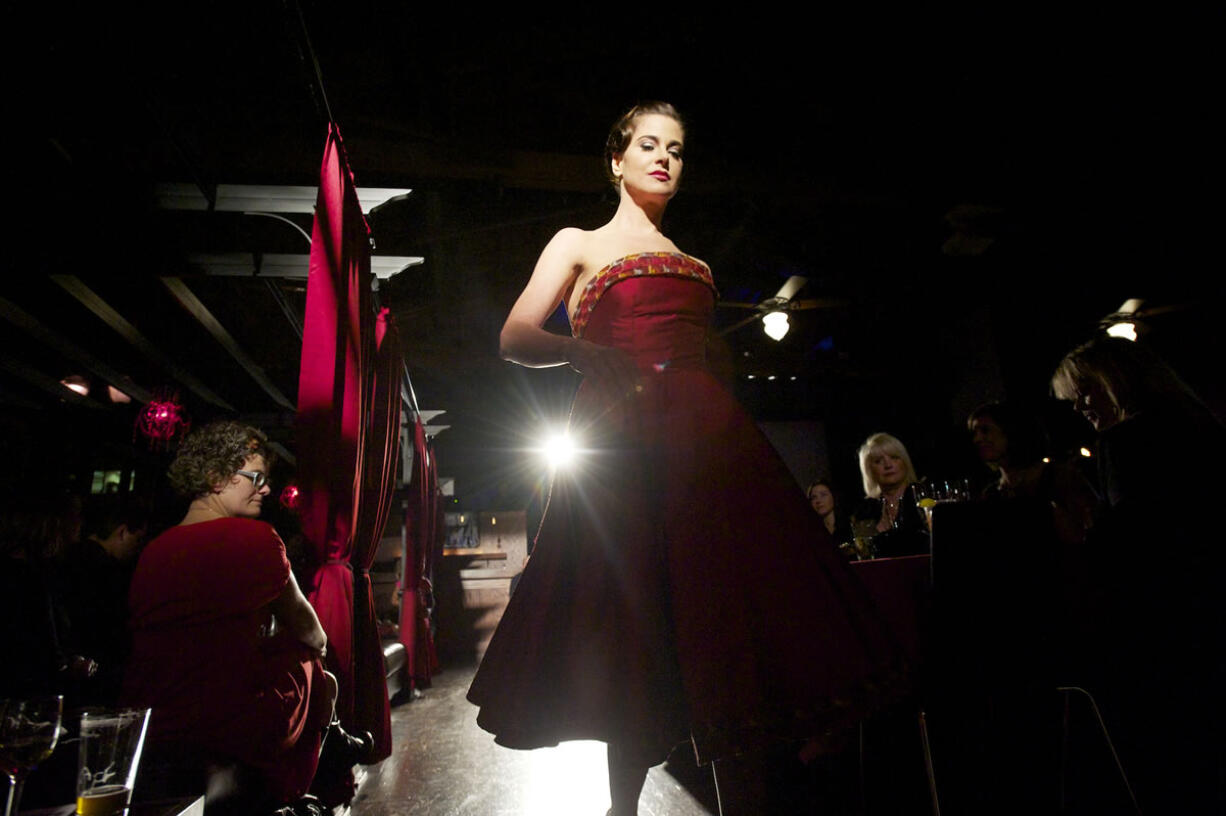 The crowd in the Atrium Lounge watches Catherine Rae's satin red dress on the runway.