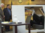 Defense expert witness Jim Pierce positions former Washougal police Officer Robert Ritchie, second from left, and his attorney, Jaime Goldberg, right, Thursday to re-enact what happened between Ritchie and Tyler Lampman inside a life-size model of Ritchie's patrol car.