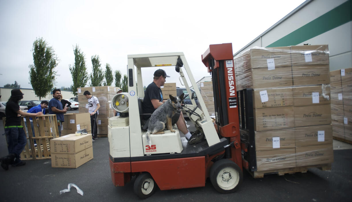 Mike Brackenbrough, who does inventory control for United Home Technologies, takes his dog, Cras, for a ride while he prepares product for shipping the company's Salmon Creek facility.