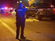 A Vancouver police officer takes photos of the scene where a man was struck by a pickup and killed Monday evening while crossing East Mill Plain Boulevard near Andresen Road.