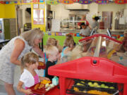 Washougal: Washougal School District Early Learning Technician Lisa Young guides children through the lunch line in July at Hathaway Elementary School.