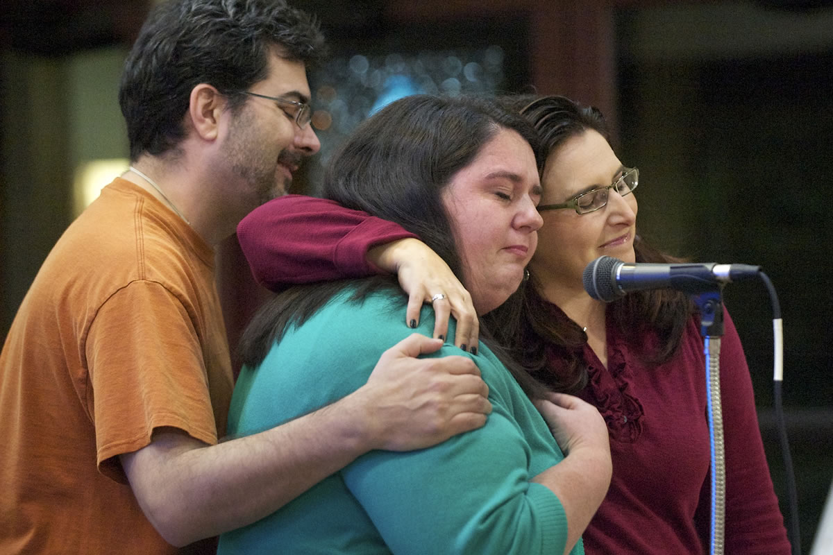 Jason Covington, a volunteer with OneAmerica Vancouver, left, and family friend Loriann Whalen, right, comfort Natasha Derthick, center, as she gives an emotional presentation on immigration reform at St. John the Evangelist Catholic Church in Vancouver. Derthick's sister, Karen Byrne, a native of Ireland who spent much of her childhood in Vancouver, is unable to live near her family in Clark County because of delays in the U.S. immigration system.