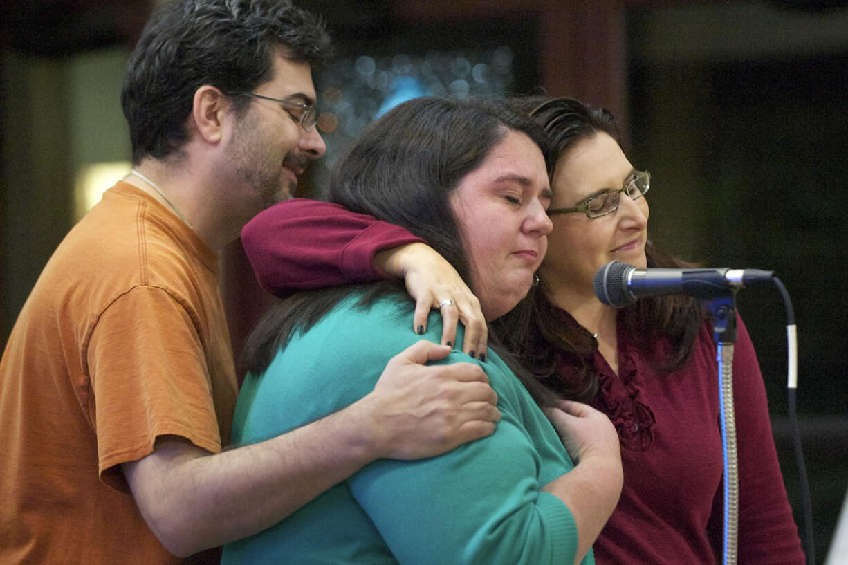 Jason Covington, a volunteer with OneAmerica Vancouver, left, and family friend Loriann Whalen, right, comfort Natasha Derthick, center, as she gives an emotional presentation on immigration reform at St. John the Evangelist Catholic Church in Vancouver. Derthick's sister, Karen Byrne, a native of Ireland who spent much of her childhood in Vancouver, is unable to live near her family in Clark County because of delays in the U.S. immigration system.