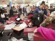 Bargain-hunting Black Friday shoppers rifle through a display of specially priced fashion boots in J.C.