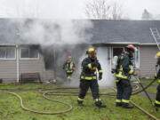 Firefighters respond to a house fire Tuesday morning on Evergreen Boulevard in Vancouver.