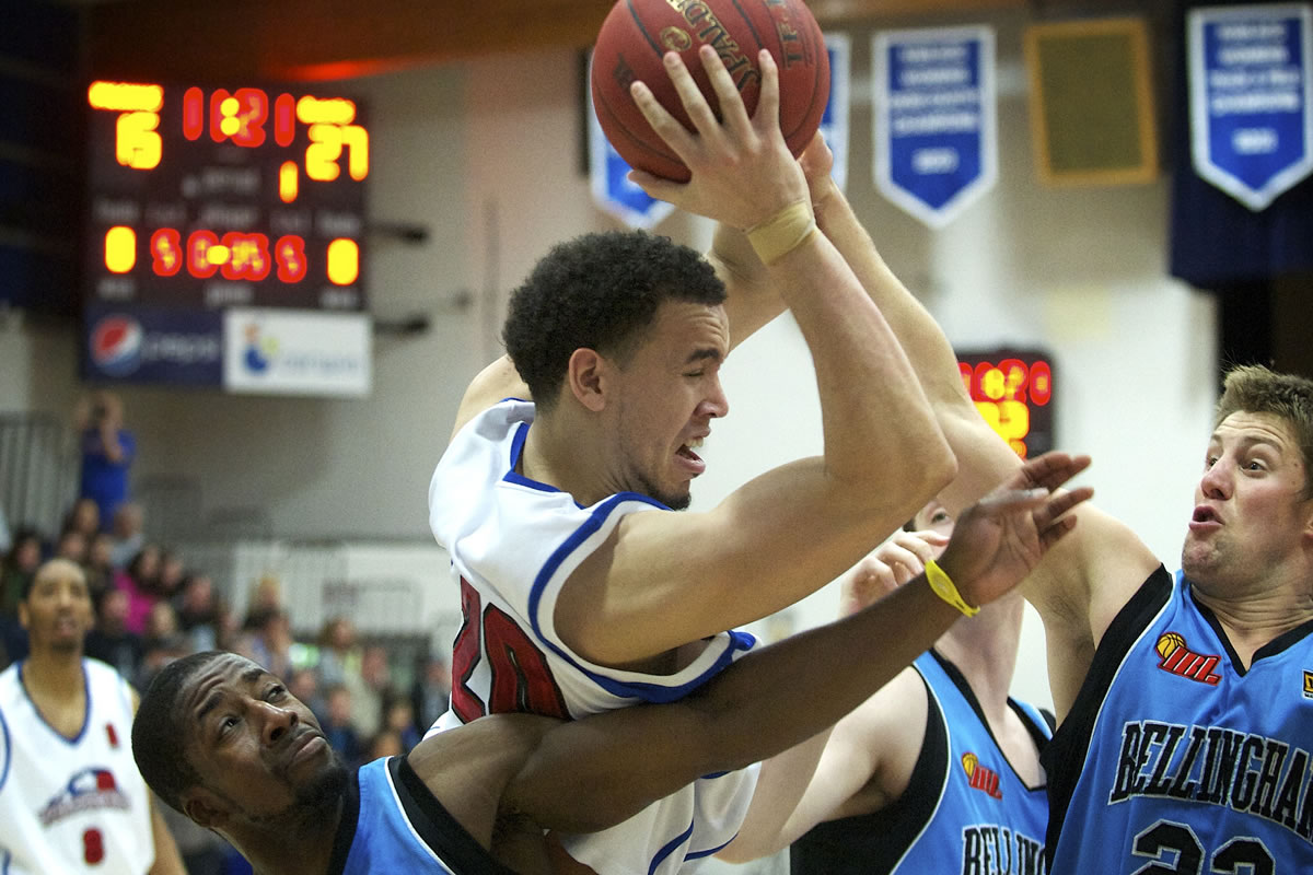 Chehalis Tapscott (20) of the Vancouver Volcanoes grabs an offensive rebound against Drew Ready (15), lower left, of the Bellingham Slam during the Volcanoes home opener on Sunday.