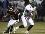 Evergreen running back Rey Green (7) escapes tackle by Battle Ground defensive back Josh Lemar in 4A GSHL opener.