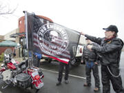 Barry Smith, a Patriot Guard rider from Rainier, Ore., shows the Second Amendment flag that hangs on the back of a motorcycle outside Coffee Villa in Vancouver, where gun supporters gathered for an open carry event Saturday.