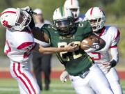 Evergreen ball carrier Ray Donalde powers past Fort Vancouver defender Taylor VanHeck at McKenzie Stadium, Friday, August 31, 2012.