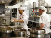 Clark College students Louis Cayson, left,  and Timothy Henley prepare food at the Clark College cafeteria.  The college's culinary arts program is undergoing a redesign that will change the curriculum and possibly upgrade dining and kitchen facilities.