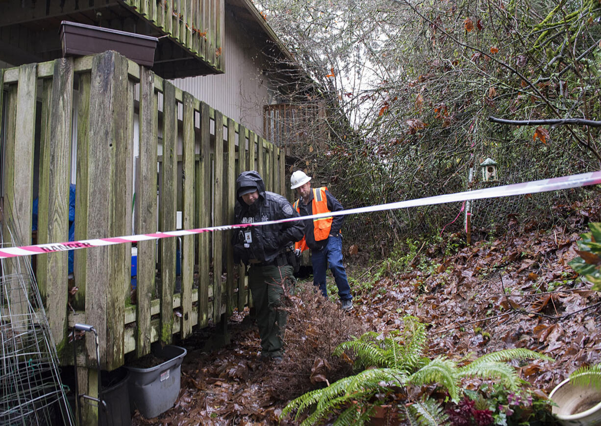 Deputy Albin Boyse, left, and Ken Price of the Clark County Public Works Department investigate the scene of a mudslide Monday afternoon, Dec. 7, 2015 at Greenway Estates in Hazel Dell.