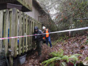 Deputy Albin Boyse, left, and Ken Price of the Clark County Public Works Department investigate the scene of a mudslide Monday afternoon, Dec. 7, 2015 at Greenway Estates in Hazel Dell.