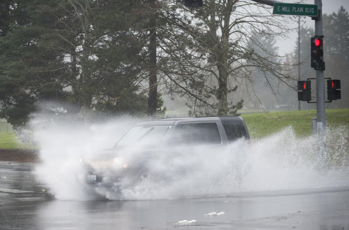 Cars blast though giant puddles on Mill Plain Boulevard in Vancouver on Dec. 7. Even with a couple of more days left in the month, this December is now the wettest in the city’s history.