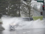 Cars blast though giant puddles on Mill Plain Boulevard in Vancouver on Dec. 7. Even with a couple of more days left in the month, this December is now the wettest in the city’s history.