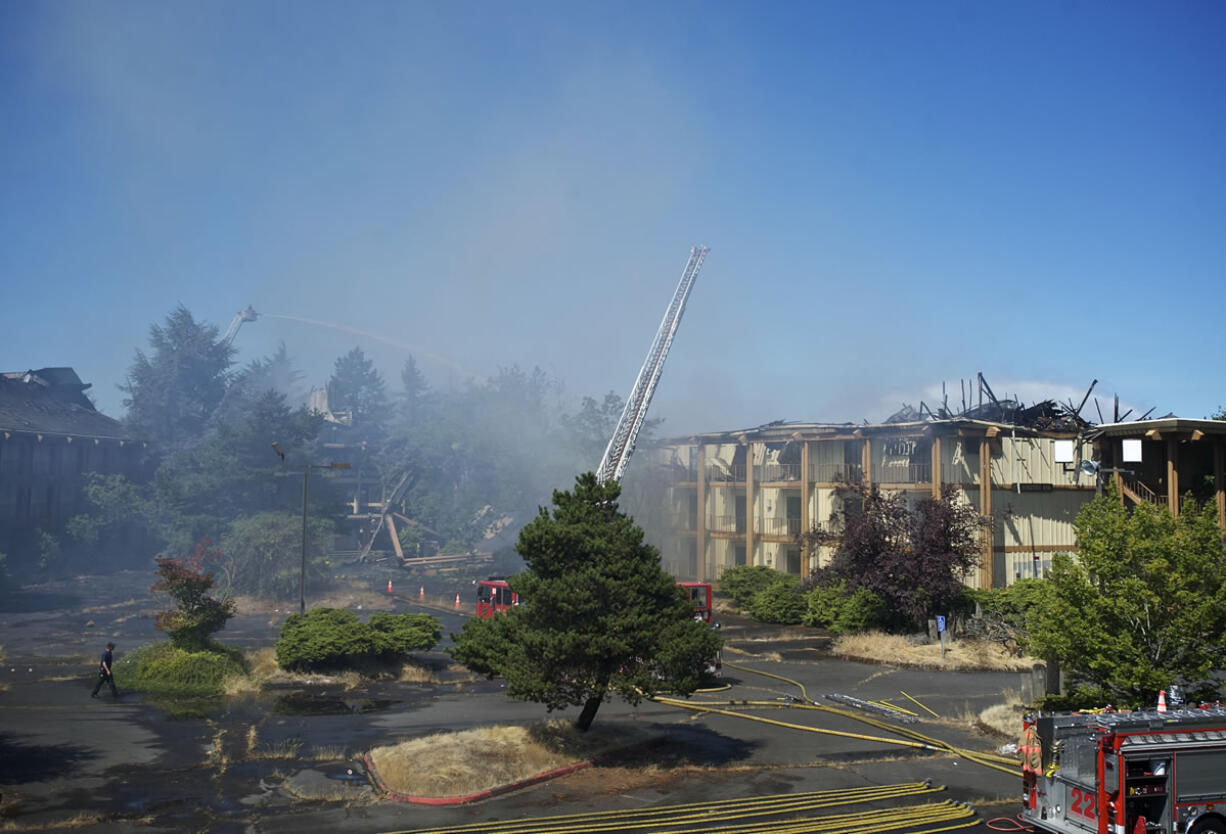 Portland firefighters dump water on the vacant Thunderbird Hotel on Hayden Island after a fire started early Sunday morning.