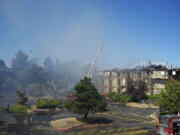 Portland firefighters dump water on the vacant Thunderbird Hotel on Hayden Island after a fire started early Sunday morning.