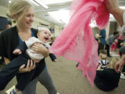 Heather Stuart, left, and her 7-month-old son, Obadiah, laugh as dad Steve Stuart, a Clark County commissioner, playfully waves a pink scarf during the &quot;Love, Talk, Play&quot; event Thursday at the Center for Community Health in Vancouver.