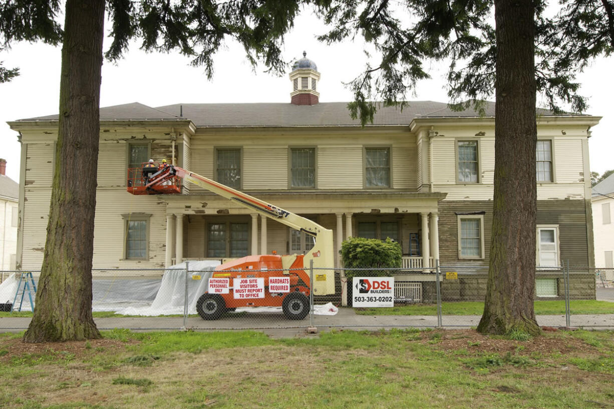 A crew works on part of the gutter system Thursday during a preservation project on the former headquarters building at Vancouver Barracks.