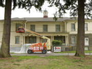 A crew works on part of the gutter system Thursday during a preservation project on the former headquarters building at Vancouver Barracks.