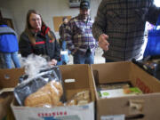 Deborah Schitz, left, and Cark Hawes, center, of La Center, pick up food  Jan.