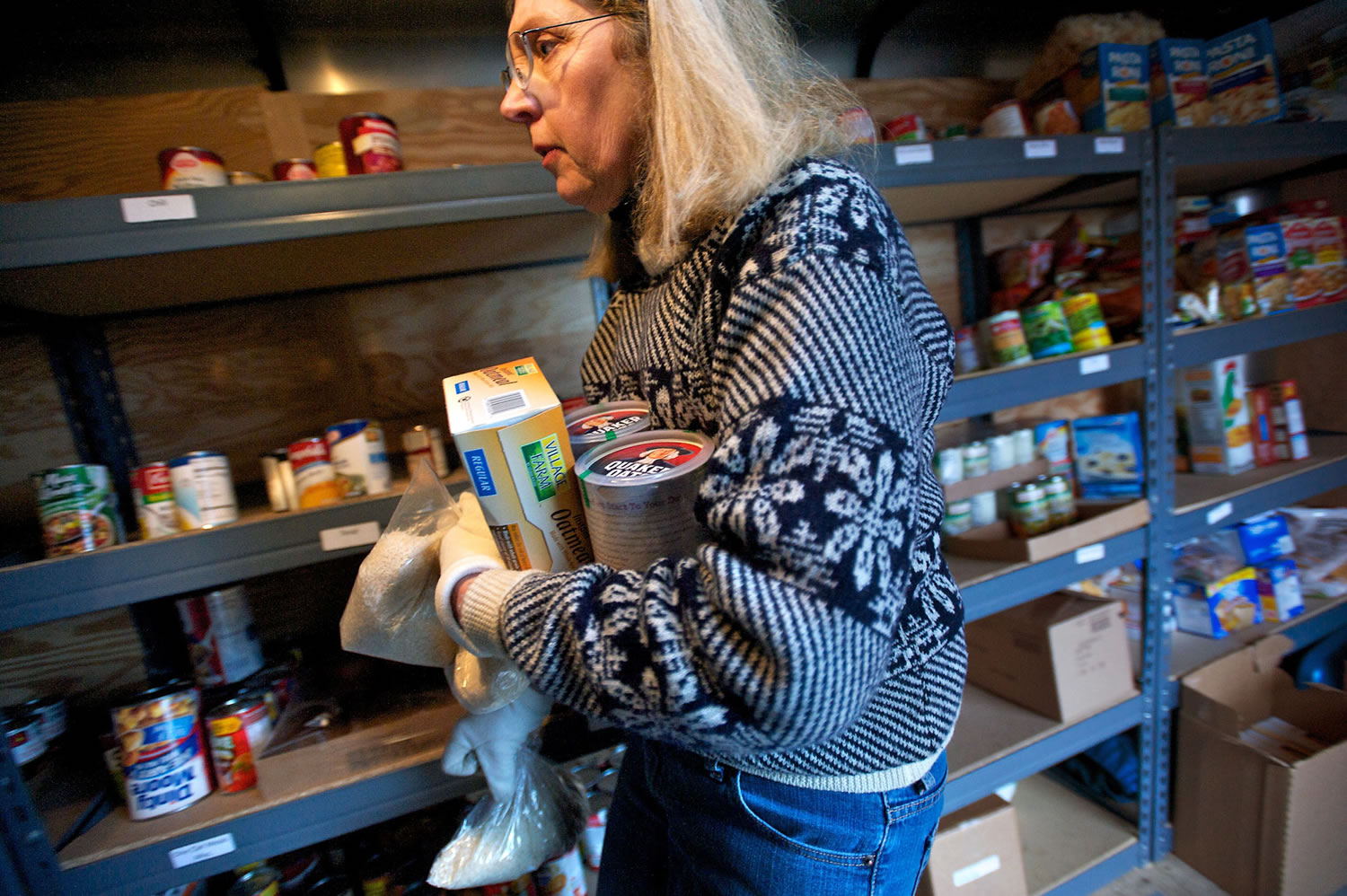 Lewis River Mobile Food Bank volunteer Denise Wilder works in the organization's trailer Sunday, helping a client.