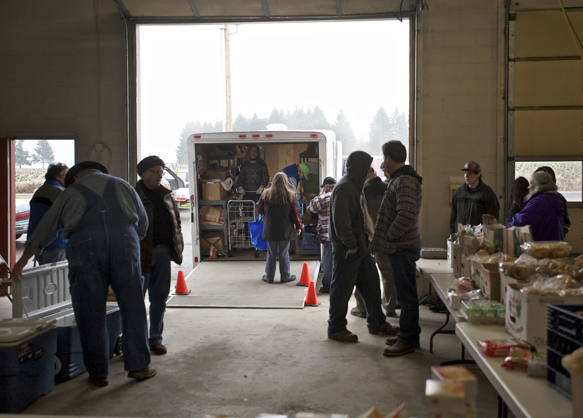 Community members gather at the fire station in View for food from the Lewis River Mobile Food Bank on Sunday.