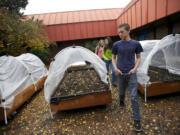 Wy'east Middle School students (front to back) Carter Wood, Reilly Dale, and Grace Taylor, all 13, examine the raised bed gardens they helped create with a Vancouver Watersheds Alliance grant.