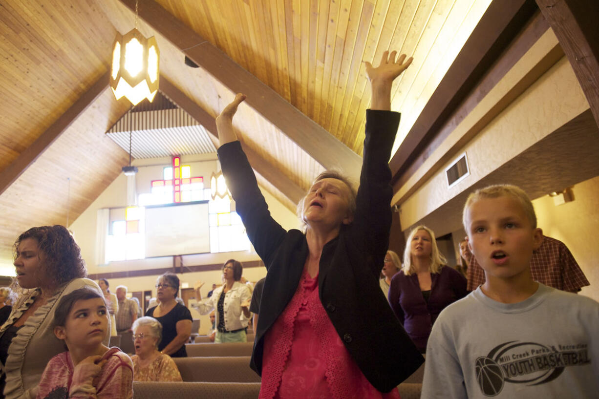 Olga Fisenko, center, worships at the Brush Prairie Baptist Church on Aug. 25.