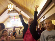 Olga Fisenko, center, worships at the Brush Prairie Baptist Church on Aug. 25.