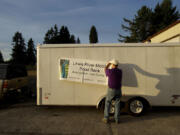 Lewis River Mobile Food Bank volunteer Wayne Howell readies the organization's trailer for clients on the evening of Oct. 17 at a pilot location on 41st Street in the La Center area.