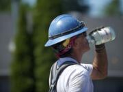 Carpenter Tom Richards stops for water while working on the St. Johns Boulevard bridge at state Highway 500 on Friday, the sixth straight day above 90 degrees in Vancouver.