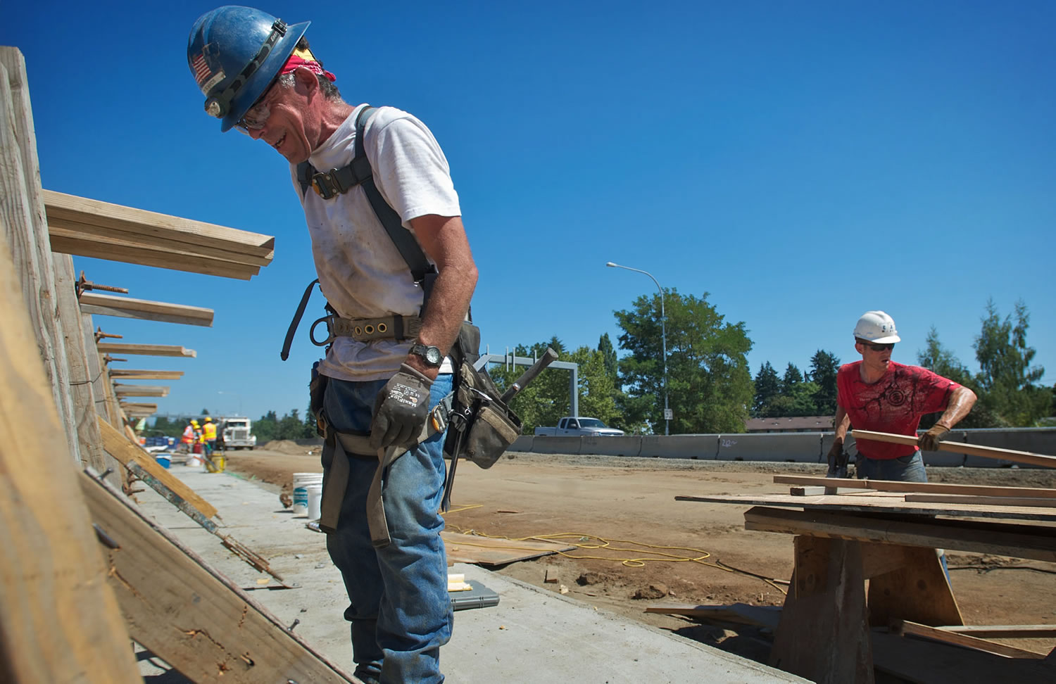 Carpenters Tom Richards, left, and Jesse Marks work on concrete forms for a barrier on the St. Johns Boulevard bridge at Highway 500 on Friday.