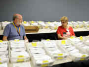 Election officers Josie Karling, right, and Gay Lincoln sit among ballots on Tuesday at the Clark County Elections Office in Vancouver. The vote-by-mail, top-two primary elections took place on Tuesday, and the general election is Nov.