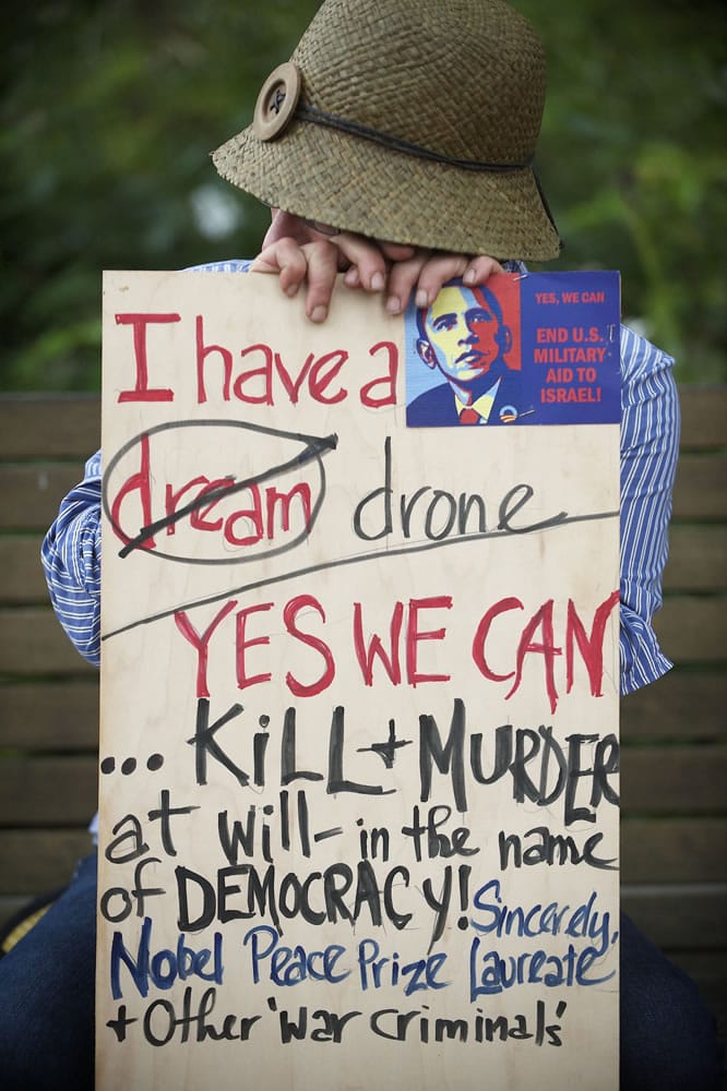 Italia Laruffa of Vancouver holds his sign Monday while listening to speakers at Esther Short Park.